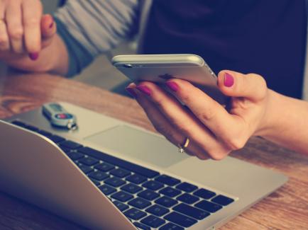 Woman using laptop and calculator